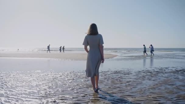Frau Spaziert Einem Windigen Sonnigen Tag Strand Mit Wässrigen Pools — Stockvideo