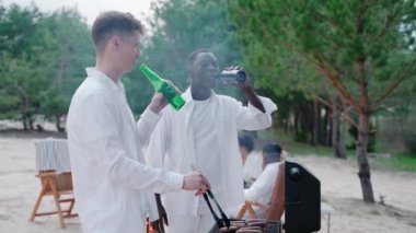 Plaj partisinde barbekü yapan, şişelerden içen yakışıklı genç adamlar. Arkadaşlar doğadaki bir kampta barbekü yaparken konuşurlar. Bir grup arkadaş ormanda vakit geçirir. Yüksek kalite 4k görüntü