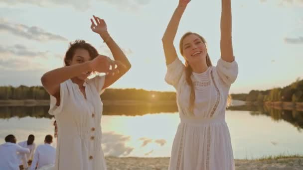 Zwei Freundinnen Tanzen Und Springen Auf Einer Strandparty Bei Sonnenuntergang — Stockvideo