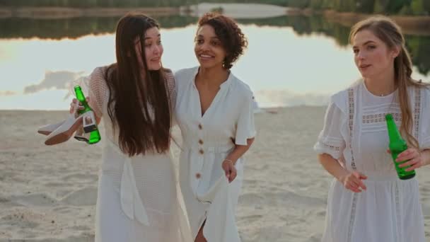 一群女性朋友在派对上在湖滨玩乐 走着和拥抱喝酒的女人 人们在日落时在湖边举行聚会 高质量的4K镜头 — 图库视频影像