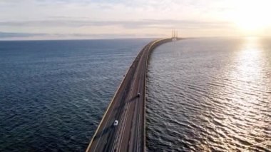 Drone flying over an Oresund bridge at the sunset in summer. Cinematic shot of long tunnel bridge between Sweden and Denmark. Oresund bridge from the top. High quality 4k footage