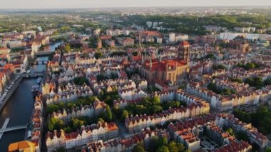 The camera flies over the old city center in the Denmark. Aerial shot of red roof houses in the sunset light. European city center. High quality 4k footage