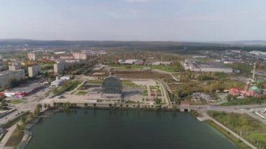 Şehirdeki modern binanın havadan görünüşü bir havuzun yanında çamaşır makinesi şeklinde. Binanın etrafında park yeri, çocuk parkı, yürüyüş yolları ve çimlerin olduğu güzel bir alan var. Çok katlı evler ve sanayi bölgesi.