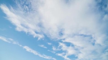 Bulutların zamanı güneşli gökyüzünde ilerliyor. Çerçevenin sonunda, bir uçak arkasında iz bırakarak uçar.