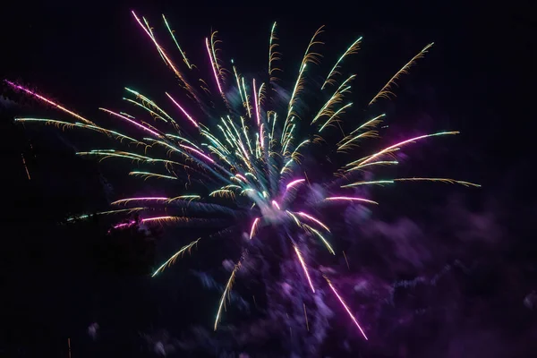 Fogos de artifício roxos e verdes celebrando novos anos — Fotografia de Stock