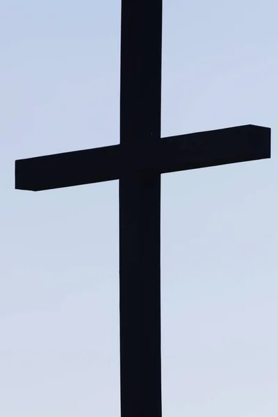 Céu azul pálido com cruz silhueta escura — Fotografia de Stock
