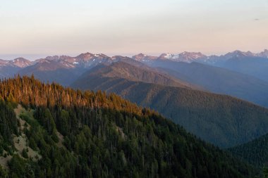 Akşamüstü güneşli dağlar ve orman tepeleri