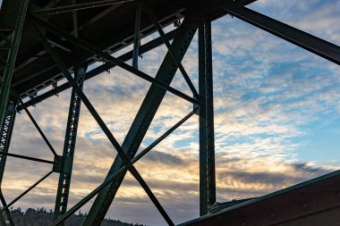 Bir uçurumdan diğerine geçen eski yeşil bir köprü.