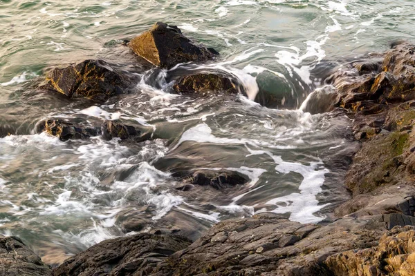 Хвилі розбиваються на скелі і збираються навколо каменів — стокове фото