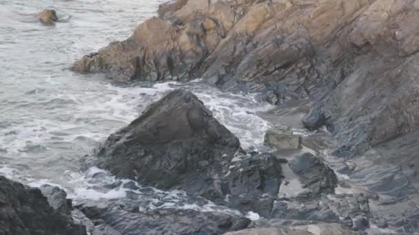 Grote golven botsen tegen een rotsachtige rotswand in een park — Stockvideo