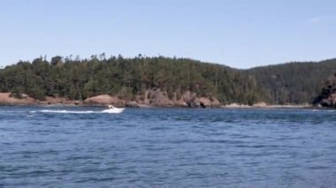 Parlak beyaz sürat teknesi okyanusta hızla ilerliyor.