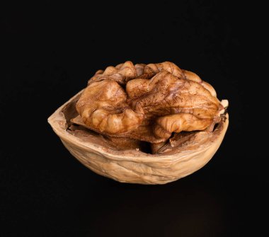 Siyah bir arka planda yarım katmanlı ceviz çekirdeği. Yakın plan.