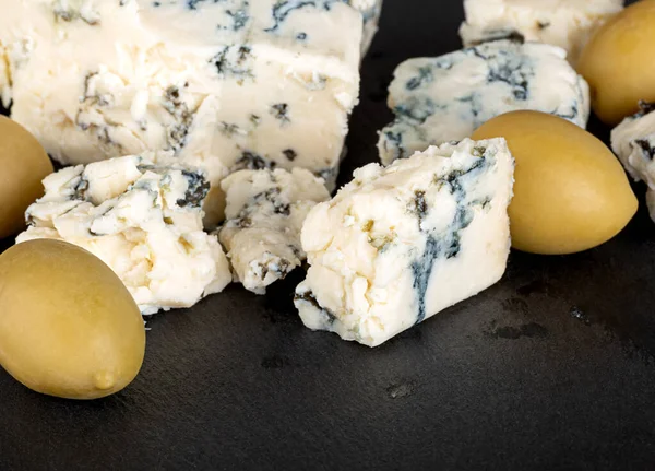 黒を基調とした青カビと緑のオリーブのチーズ — ストック写真
