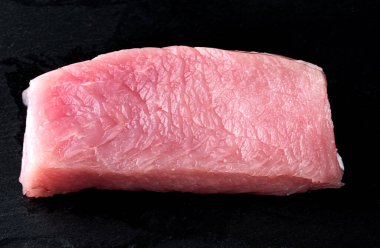 Güzel siyah bir arka planda taze çiğ hindi filetosu.