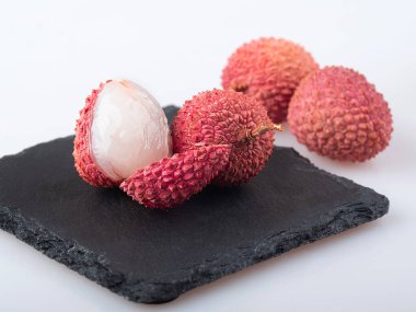 Kabuklu ve soyulmuş lychee beyaz arka planda izole edilmiş.