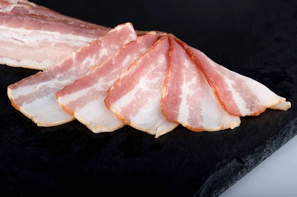 Slices Fresh Juicy Bacon Black Cutting Board — стоковое фото