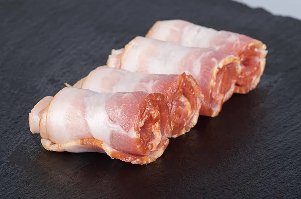 Raw Bacon Rolls Black Cutting Board — Zdjęcie stockowe