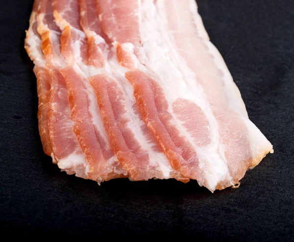 Slices Raw Bacon Isolated Black Background Close Top View — Stock Fotó