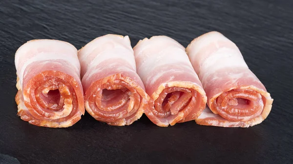 Rolls Fresh Bacon Black Cutting Board — стоковое фото