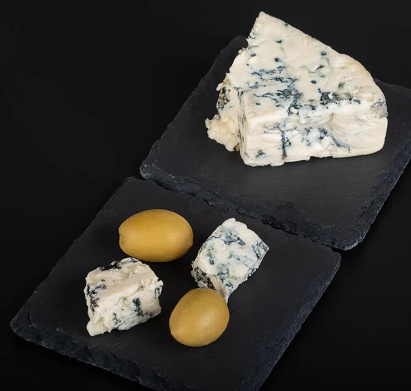 黒を基調とした青いカビと大きな緑のオリーブのチーズ — ストック写真