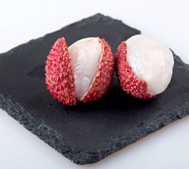 Lychee siyah tahta üzerinde soyulmuş. Makro fotoğrafçılık. yakın plan