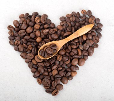 Kahve çekirdekli ahşap kaşık kalp şeklinde kahve çekirdekleri üzerinde yatar. Üst görünüm