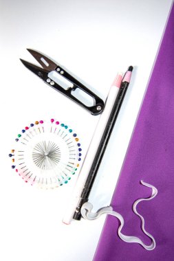 Dikiş aksesuarlarından (santimetrik bir mezura, kumaş için süpürülmüş düğmeler, renk iplikleri)