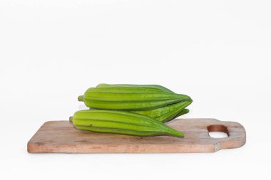 Okra on a wooden board isolated on white background