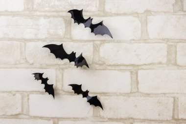 Beyaz tuğlalı duvarda yarasalar. Cadılar Bayramı partisi için dekorasyon