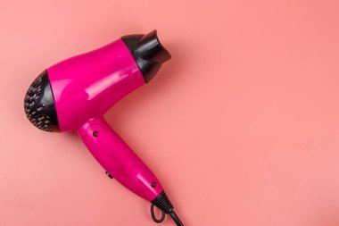 Pembe arka planda pembe saç kurutma makinesi. Üst görünüm
