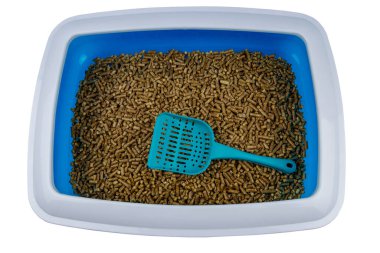 Beyaz arka planda kepçeyle doldurulmuş kedi kumluğu.