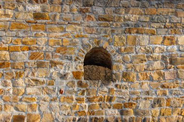 Eski taş duvarın arka planında bir boşluk var.