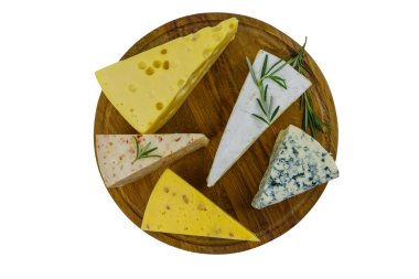 Beyaz arka planda izole edilmiş ahşap kesim tahtasındaki çeşitli peynir çeşitleri. Üst görünüm