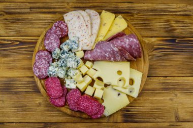Tahta masada İtalyan salam ve peynirinden oluşan antipasti tabağı. Üst görünüm