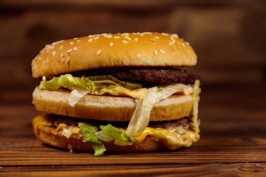 Ahşap masada lezzetli büyük hamburger.