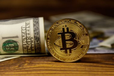 Altın bitcoin ve ahşap arka planda dolar