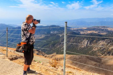 Antalya 'nın Kemer ilçesi yakınlarındaki Tahtali dağının tepesinde fotoğraf çeken profesyonel kameralı gezgin fotoğrafçı