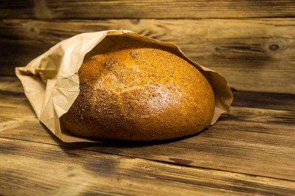 Brood Verpakt Papier Houten Tafel — Stockfoto