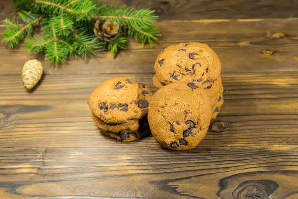 木製テーブルの上にクリスマスの装飾の前にチョコレートチップクッキー — ストック写真