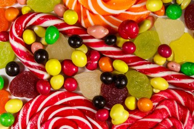 Renkli çikolata şekerleri, lolipoplar, şeker kamışı ve jöleli şekerlerin arka planı