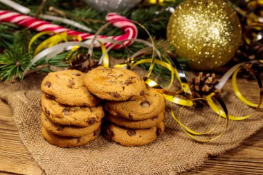 Tahta masada Noel süslemeli çikolata parçacıklı kurabiyeler.