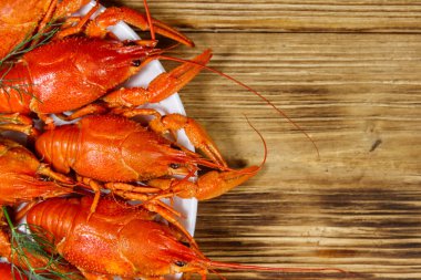 Ahşap masada kaynamış kerevit tabağı. Üst görünüm