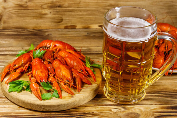 Boiled crayfish and mug of beer on a wooden table