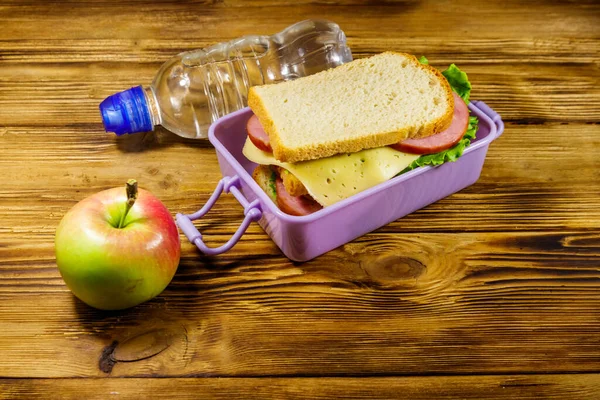 Caixa Almoço Com Sanduíches Garrafa Água Maçã Uma Mesa Madeira — Fotografia de Stock