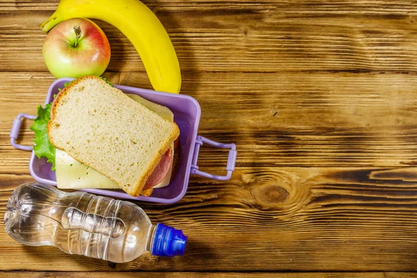 Pranzo Con Panini Bottiglia Acqua Banana Mela Tavolo Legno Vista — Foto Stock