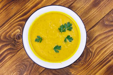 Ahşap bir masada balkabağı çorbası. Üst görünüm