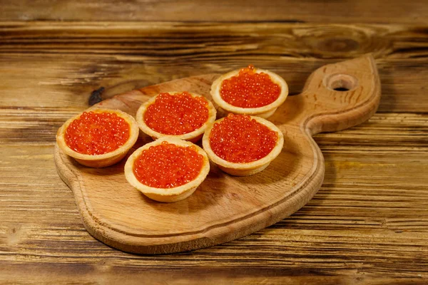 Tahta bir masada kırmızı havyarlı turta.