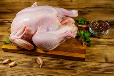 Ahşap bir masada baharatlı bütün tavuk.