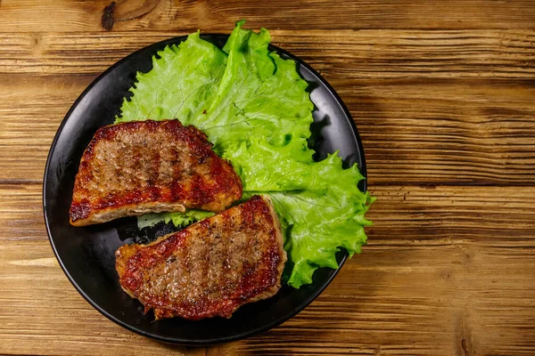 Filetes Cerdo Parrilla Con Hojas Lechuga Sobre Mesa Madera Vista —  Fotos de Stock