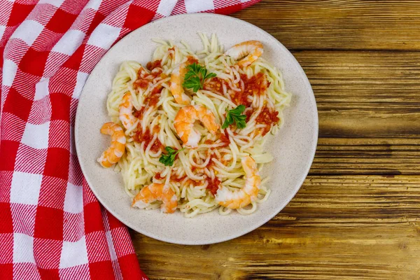 Karidesli spagetti makarna, domates sosu ve ahşap masada maydanoz. Üst görünüm